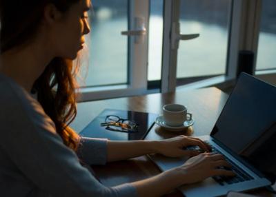 Woman types on a laptop