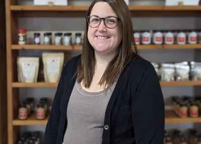 A portrait of Katie MacLeod, a white woman with brown hair and glasses